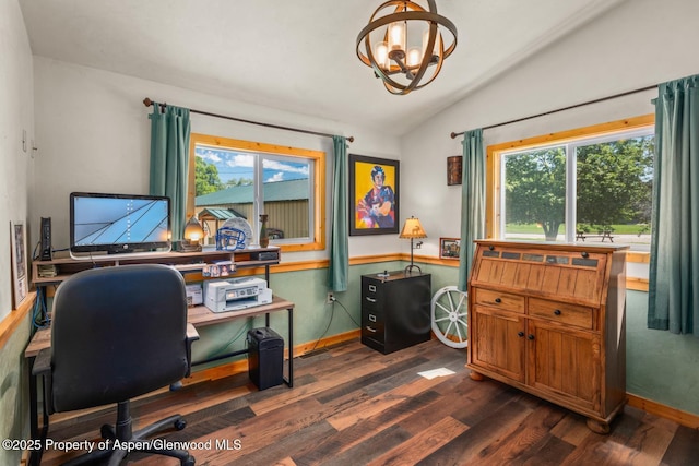 home office with a wealth of natural light, lofted ceiling, an inviting chandelier, and dark wood-style flooring