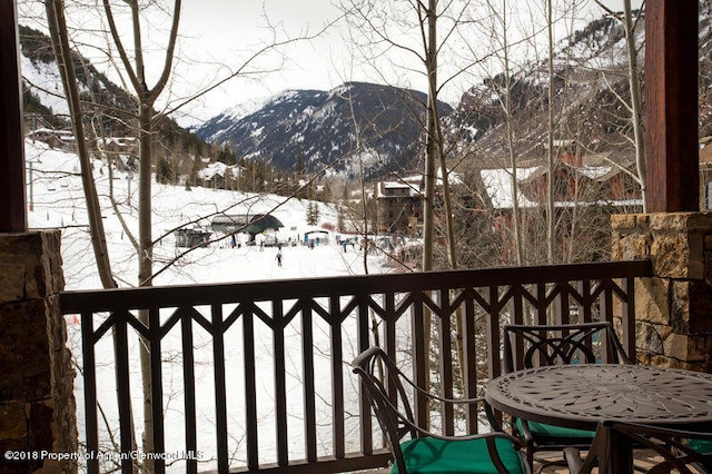 snow covered back of property with a mountain view