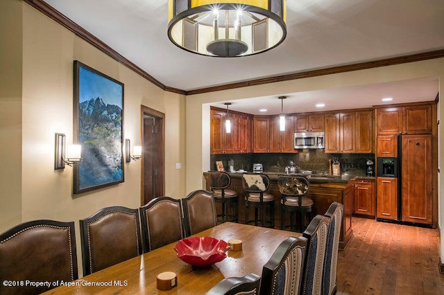 dining space featuring dark hardwood / wood-style floors and crown molding