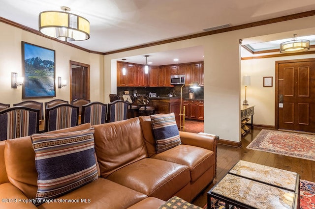 living room with dark hardwood / wood-style floors and crown molding