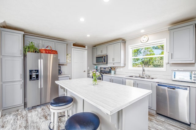 10155 6400th Rd, Montrose, CO 81401 - kitchen featuring a kitchen island, a sink, light countertops, appliances with stainless steel finishes, and a kitchen bar