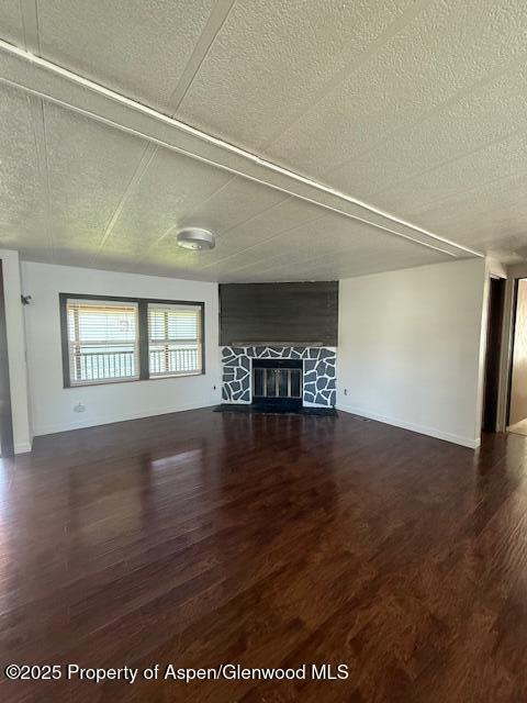 5387 County Road 154 Unit 92, Glenwood Springs, CO 81601 - unfurnished living room featuring wood finished floors, a textured ceiling, and a fireplace