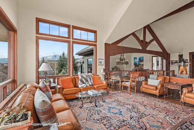 living room featuring high vaulted ceiling, an inviting chandelier, and wood finished floors