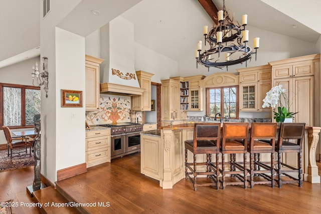 kitchen featuring visible vents, cream cabinets, an inviting chandelier, range with two ovens, and custom exhaust hood