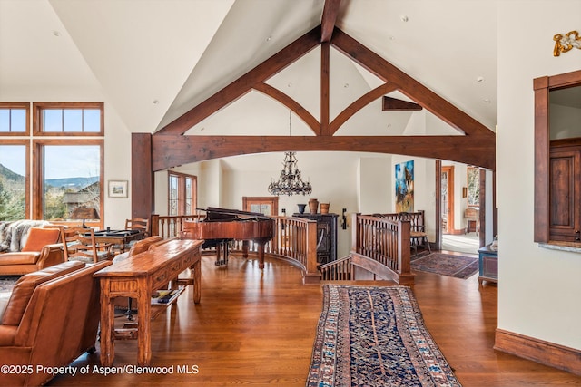 dining space featuring a notable chandelier, wood finished floors, a mountain view, and high vaulted ceiling