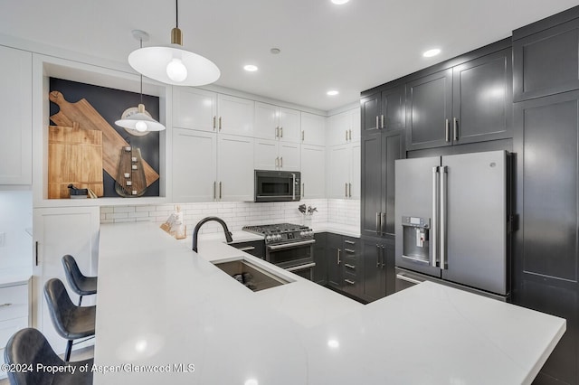 kitchen with high end appliances, backsplash, sink, hanging light fixtures, and kitchen peninsula