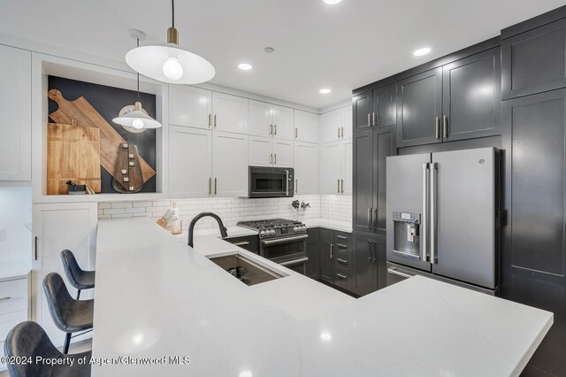 106 Clubhouse Dr Unit 180, Snowmass Village, CO 81615 - kitchen with high end appliances, backsplash, sink, hanging light fixtures, and kitchen peninsula