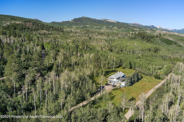 aerial view featuring a view of trees and a mountain view
