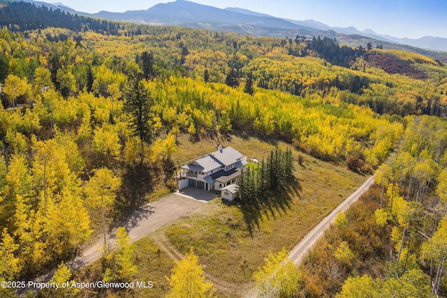 birds eye view of property with a mountain view and a forest view