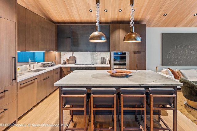 411 Wood Rd Unit 10, Snowmass Village, CO 81615 - kitchen with wooden ceiling, stainless steel appliances, modern cabinets, light wood-style flooring, and a kitchen breakfast bar