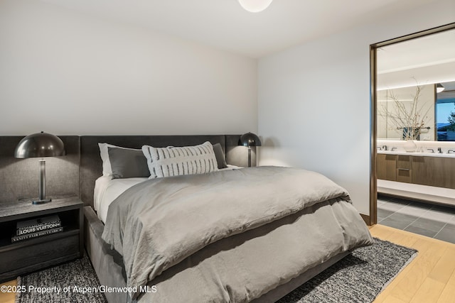 411 Wood Rd Unit 10, Snowmass Village, CO 81615 - bedroom with wood finished floors and connected bathroom