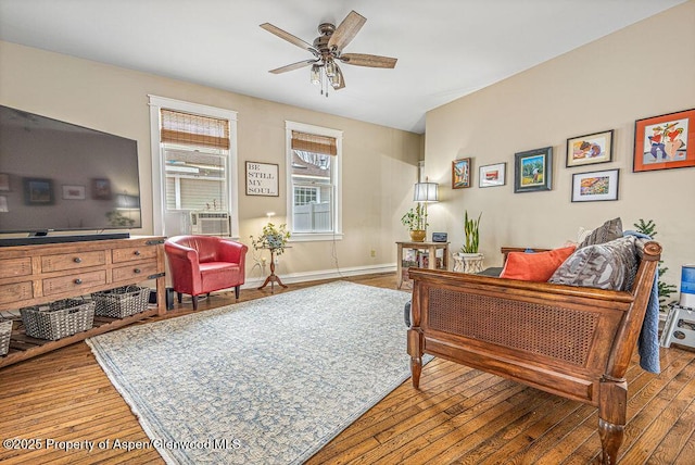 interior space with hardwood / wood-style floors, ceiling fan, baseboards, and cooling unit