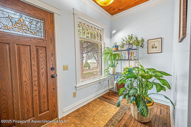 tiled foyer with crown molding, a healthy amount of sunlight, and baseboards