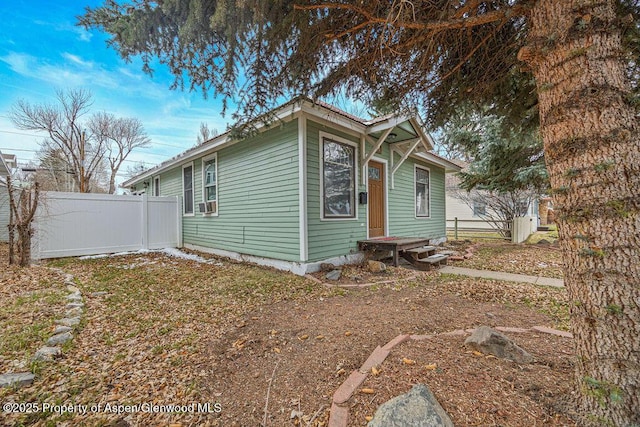view of front of property with cooling unit and fence