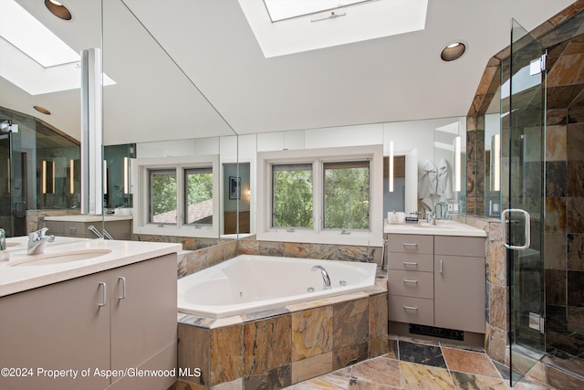 bathroom featuring separate shower and tub, lofted ceiling with skylight, and vanity