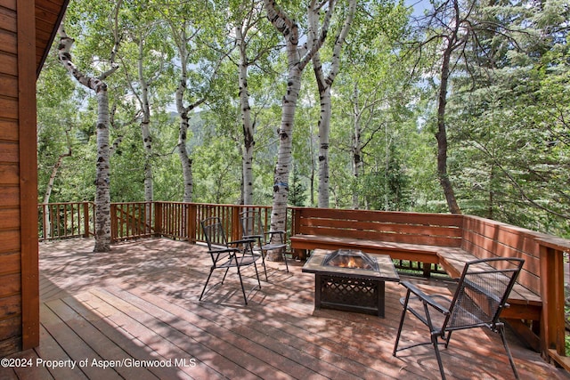 wooden terrace featuring an outdoor fire pit