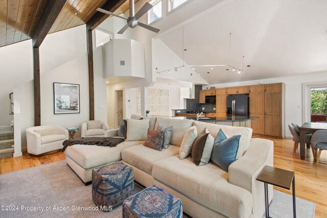 living room featuring ceiling fan, sink, high vaulted ceiling, beamed ceiling, and light hardwood / wood-style floors