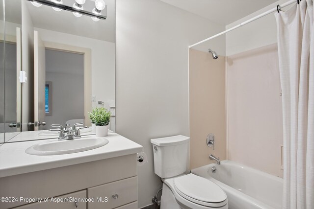 full bathroom featuring shower / bath combination with curtain, vanity, and toilet