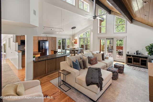 living room featuring wooden ceiling, high vaulted ceiling, light hardwood / wood-style flooring, ceiling fan, and beamed ceiling