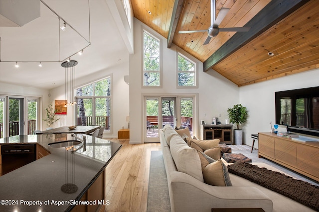 living room featuring wooden ceiling, high vaulted ceiling, sink, beam ceiling, and light hardwood / wood-style floors