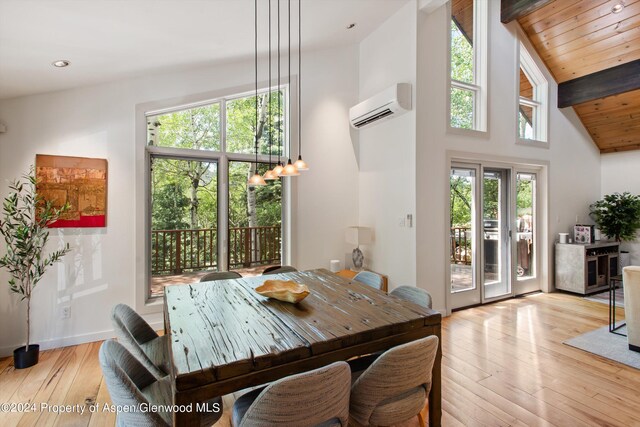 dining room featuring a wall mounted air conditioner, lofted ceiling with beams, light wood-type flooring, and wooden ceiling