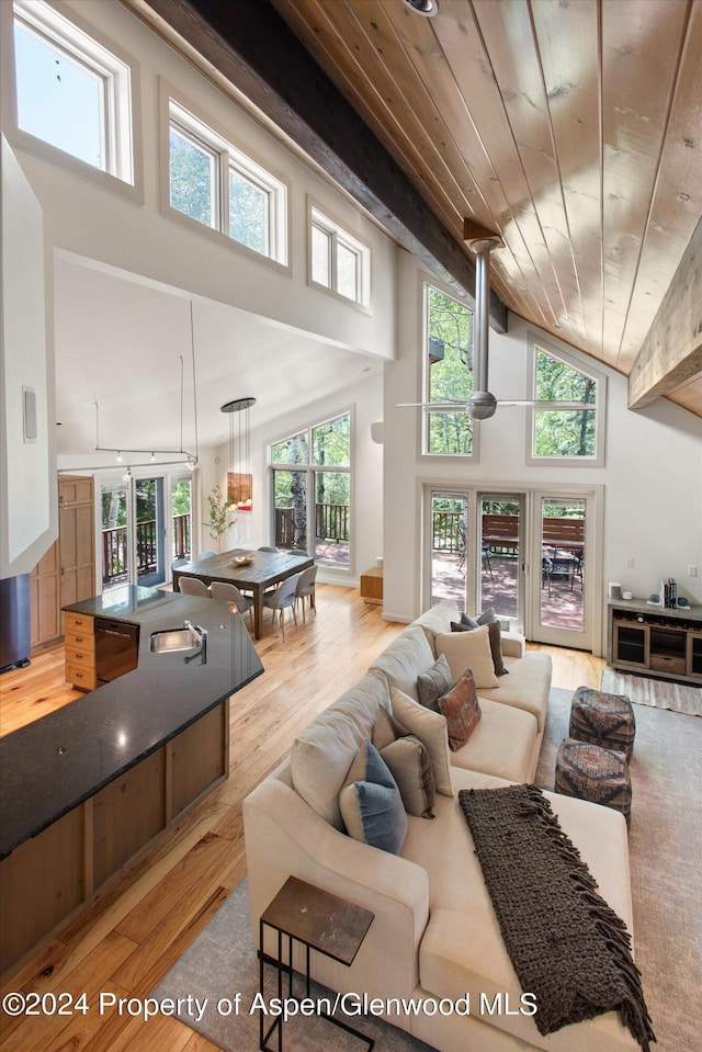 living room with light hardwood / wood-style floors, high vaulted ceiling, plenty of natural light, and wood ceiling