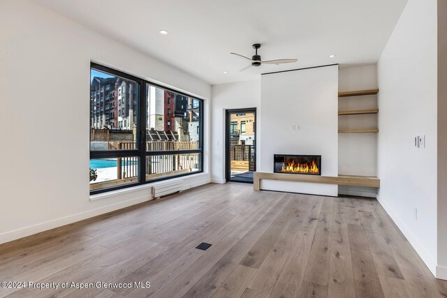 unfurnished living room with light hardwood / wood-style floors and ceiling fan