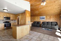 8984 County Road 300, Parachute, CO 81635 - kitchen with appliances with stainless steel finishes, light tile patterned flooring, wooden ceiling, and wooden walls