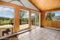 8984 County Road 300, Parachute, CO 81635 - unfurnished sunroom featuring vaulted ceiling, healthy amount of natural light, and a baseboard radiator
