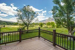 8984 County Road 300, Parachute, CO 81635 - wooden terrace featuring a mountain view and a lawn