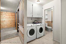 8984 County Road 300, Parachute, CO 81635 - laundry area with cabinet space, separate washer and dryer, and wooden walls
