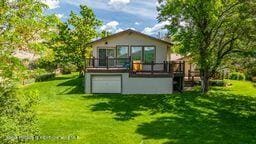8984 County Road 300, Parachute, CO 81635 - back of house featuring a wooden deck and a yard