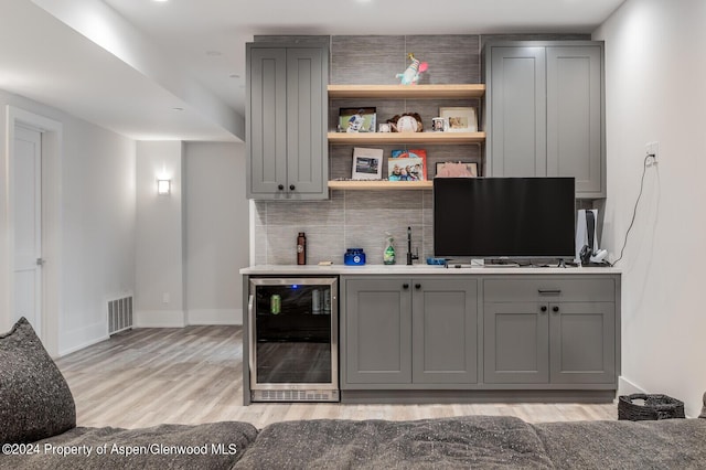 577 Fox Run Dr, Carbondale, CO 81623 - indoor wet bar featuring beverage cooler, tasteful backsplash, and light wood finished floors