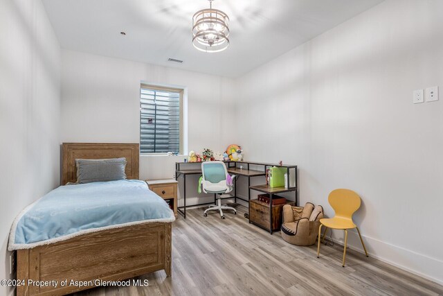 577 Fox Run Dr, Carbondale, CO 81623 - bedroom with wood finished floors and a chandelier
