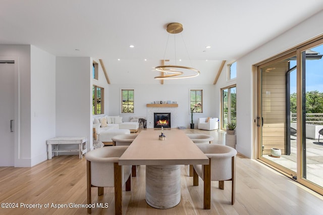 577 Fox Run Dr, Carbondale, CO 81623 - dining space featuring light wood finished floors, healthy amount of natural light, vaulted ceiling, a glass covered fireplace, and a chandelier