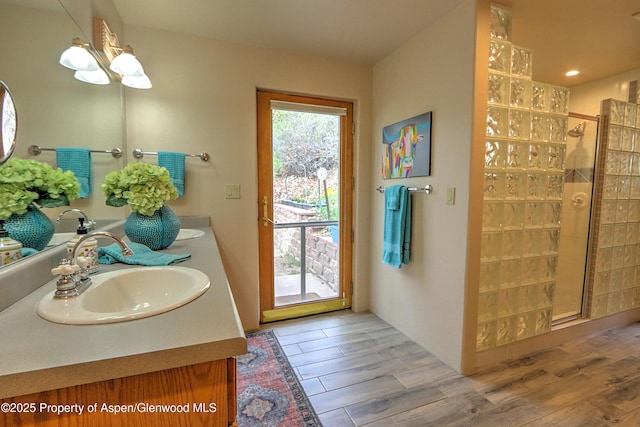 48 Creekside Ct, Glenwood Springs, CO 81601 - bathroom with tiled shower, double vanity, wood finished floors, and a chandelier