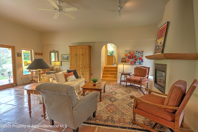 48 Creekside Ct, Glenwood Springs, CO 81601 - living room featuring arched walkways, a ceiling fan, a fireplace, stairs, and track lighting