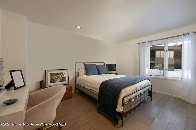 bedroom featuring baseboards, wood finished floors, and recessed lighting