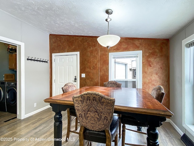 dining room featuring washer and dryer, a textured ceiling, and wood-type flooring