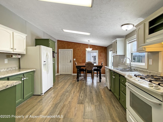 kitchen featuring sink, pendant lighting, lofted ceiling, white appliances, and green cabinetry