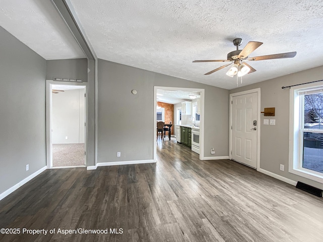 foyer entrance featuring a textured ceiling, ceiling fan, vaulted ceiling, and hardwood / wood-style flooring