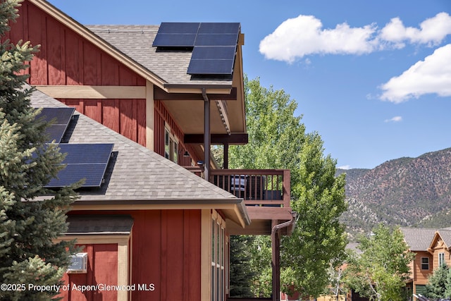 249 Whitehorse Dr, New Castle, CO 81647 - view of property exterior with roof with shingles, roof mounted solar panels, a mountain view, and a balcony