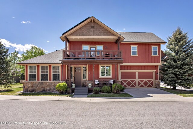249 Whitehorse Dr, New Castle, CO 81647 - view of front facade with a balcony, stone siding, a garage, driveway, and roof with shingles