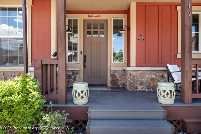 249 Whitehorse Dr, New Castle, CO 81647 - doorway to property featuring stone siding, board and batten siding, and a porch