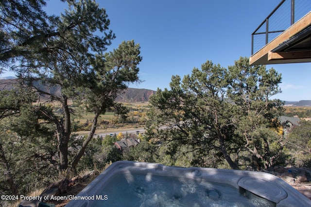 exterior space featuring a mountain view and a hot tub