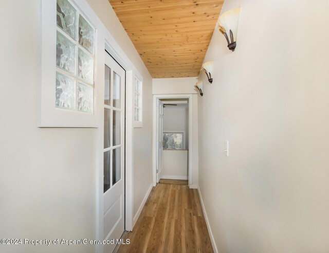 hall featuring wood-type flooring, lofted ceiling, and wood ceiling