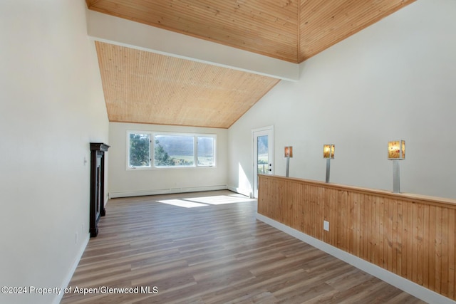 empty room with high vaulted ceiling, wooden ceiling, a baseboard heating unit, and hardwood / wood-style flooring