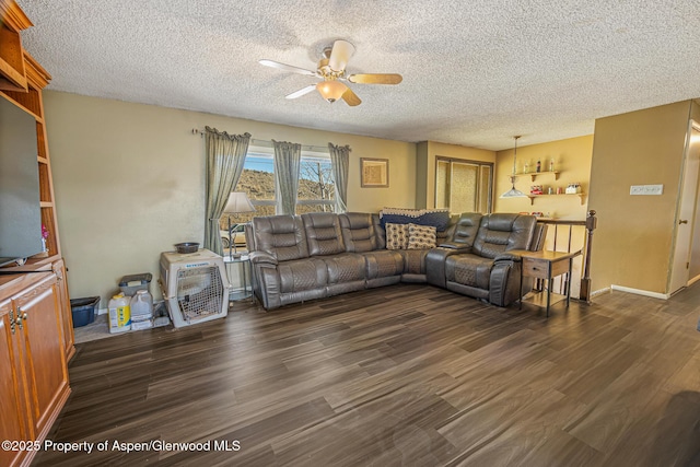 living room with baseboards, a textured ceiling, dark wood finished floors, and a ceiling fan