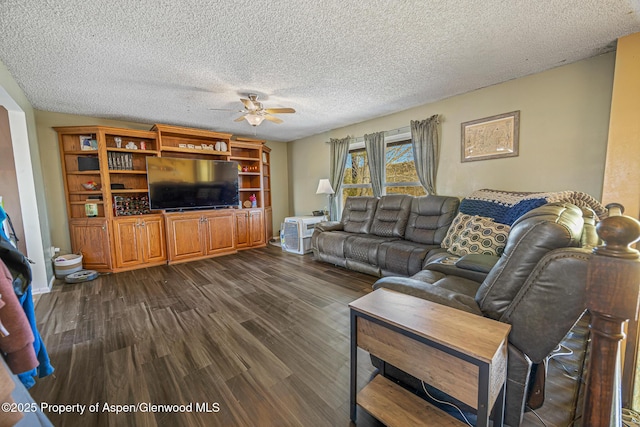 living area with a textured ceiling, a ceiling fan, and dark wood-style flooring