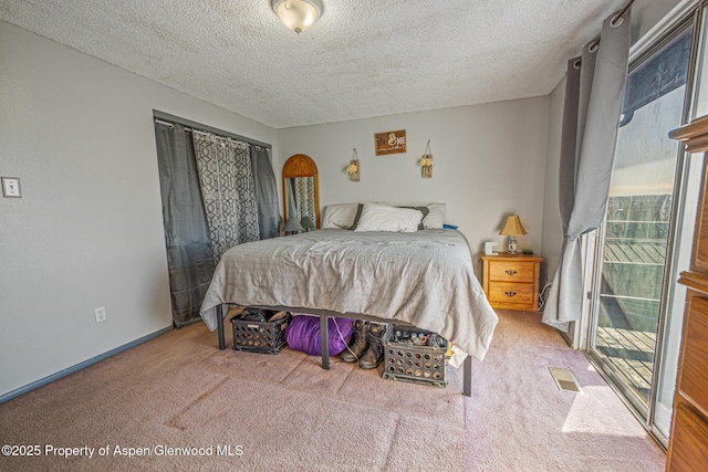 bedroom featuring baseboards, visible vents, a textured ceiling, and carpet